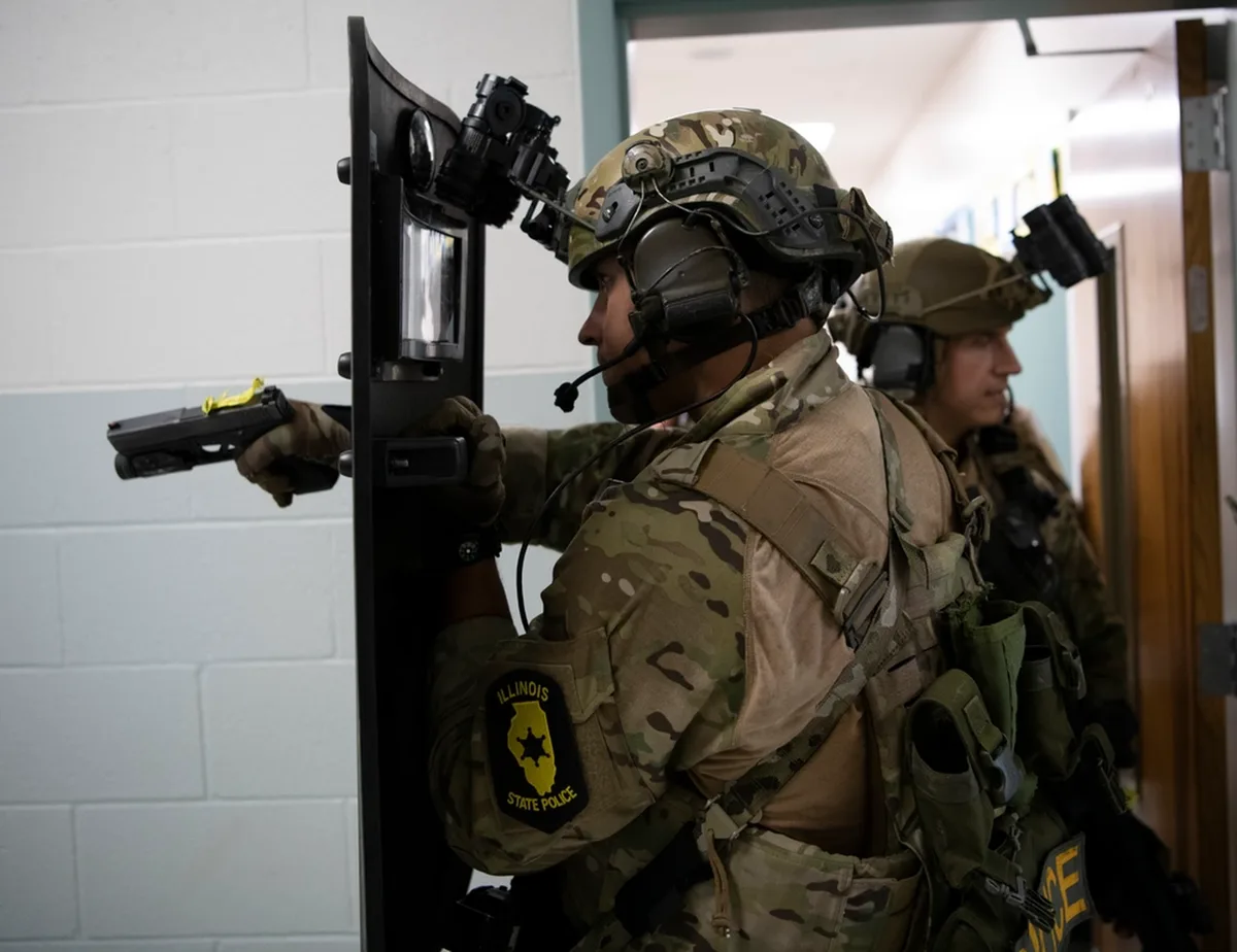 Officer entering behind a ballistic shield during active-shooter response training (DVIDS)