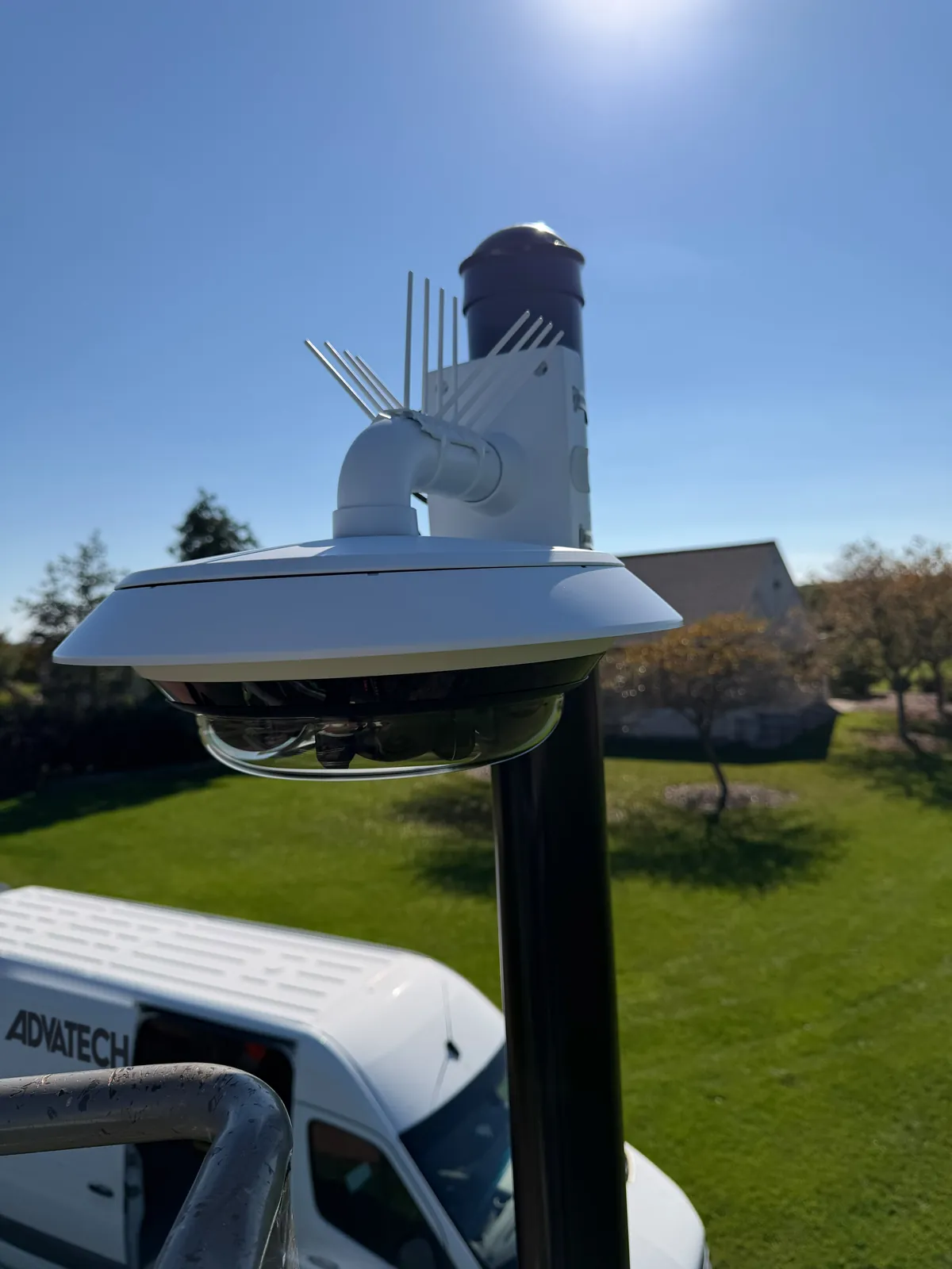 Close-up of an Axis 360-degree multi-sensor camera on a pendant mount at the top of a black camera pole in Mequon