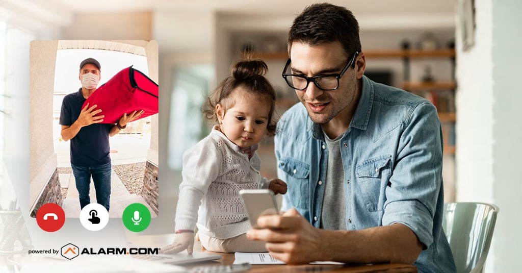 A parent checking a video doorbell while a delivery driver waits at the door