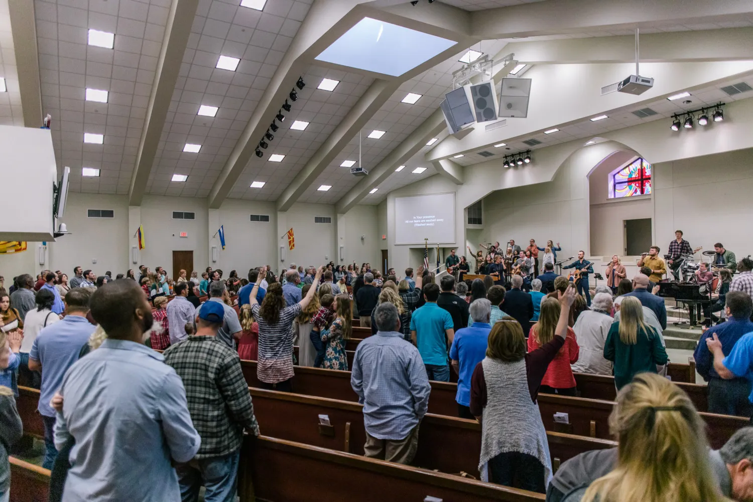 Congregation standing together in a house of worship.
