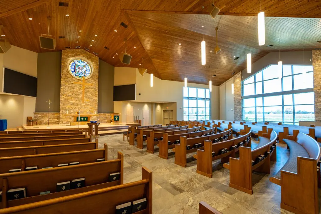 Sanctuary with pews facing a cross at the front of the room.